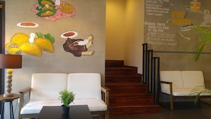 Un hall de hotel con un mural de alimentos y una escalera.