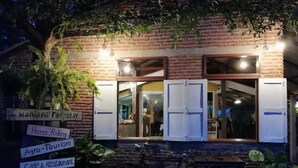 A brick building with signs for a farmstay, horse riding, agro-tourism, and a cafe & restaurant. - Wanlapa Farmstay (Lop Buri)