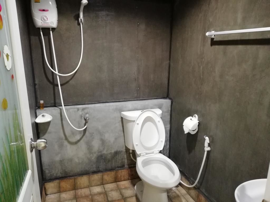 Une petite salle de bain compacte, équipée de toilettes, d’un bidet et d’un sèche-mains.