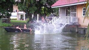 A water feature with a fountain, a boat with people, and a building with a red roof in the background. - Wanlapa Farmstay (Lop Buri)