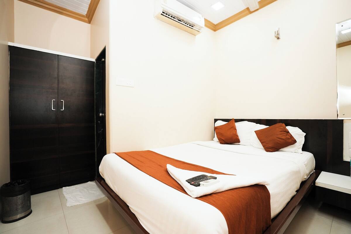 Un dormitorio ordenado con una cama, un armario y una mesita de noche.