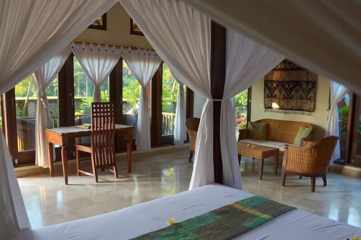 A room with a bed, a table, and two chairs.