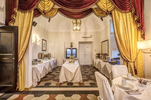 Enjoy a meal in this elegantly appointed dining area, featuring a long table and classic design elements.