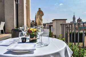 A table set for dining with a statue in the background.