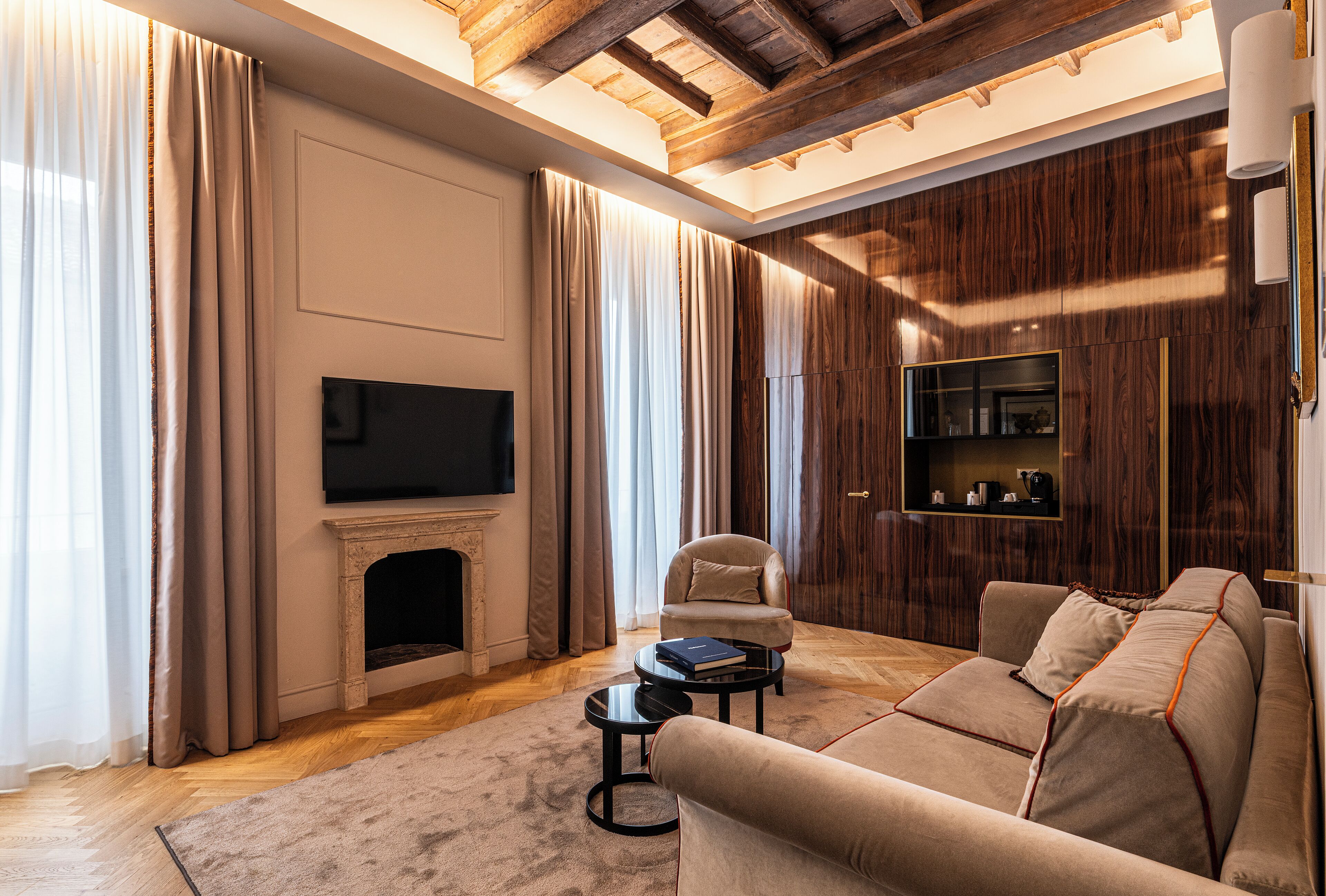 A modern living room with a fireplace, a sofa, a coffee table, and a TV.