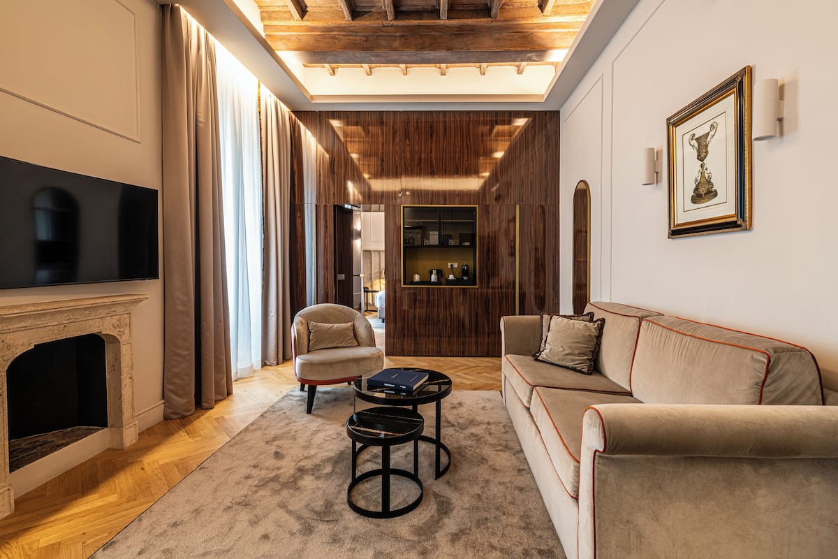 A modern living room with a fireplace, a sofa, a coffee table, and a television.