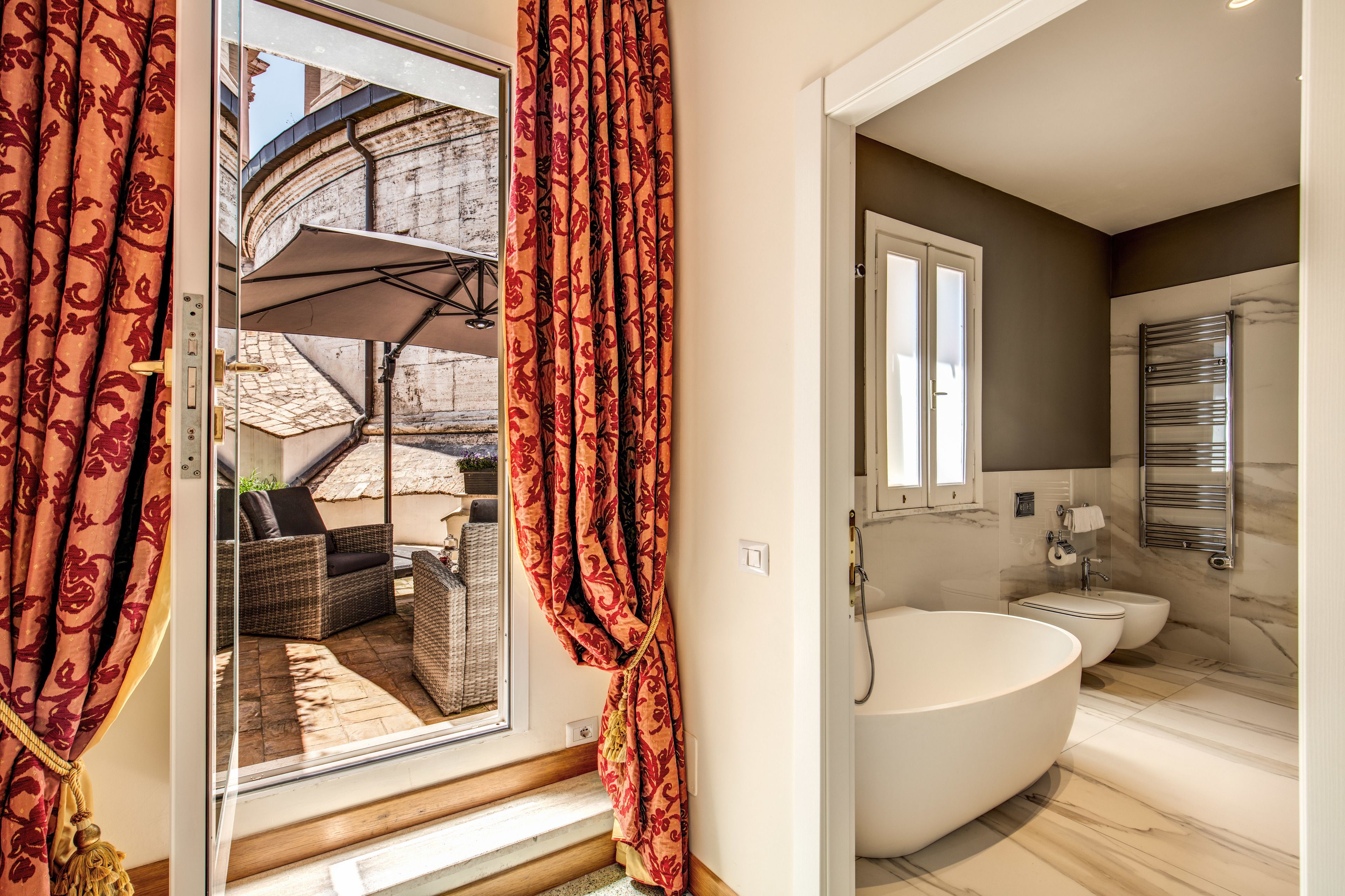 A modern bathroom with a freestanding bathtub, a toilet, and a bidet.