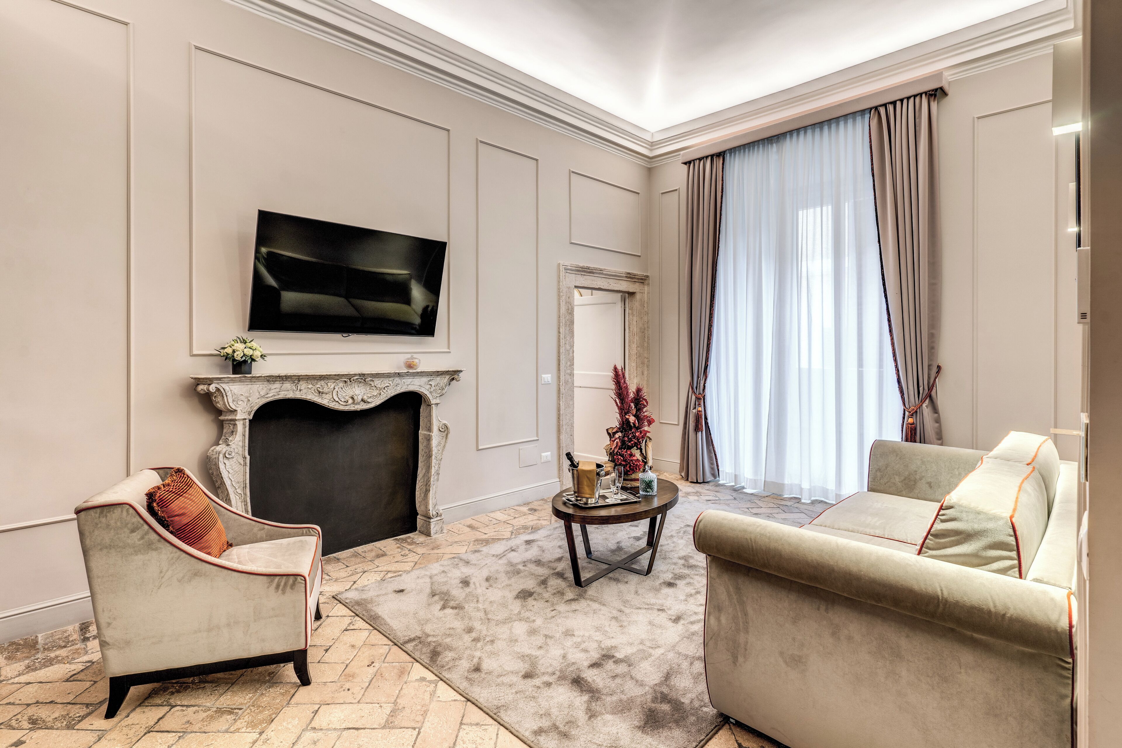 A living room with a fireplace, a sofa, a chair, a coffee table, and a television.