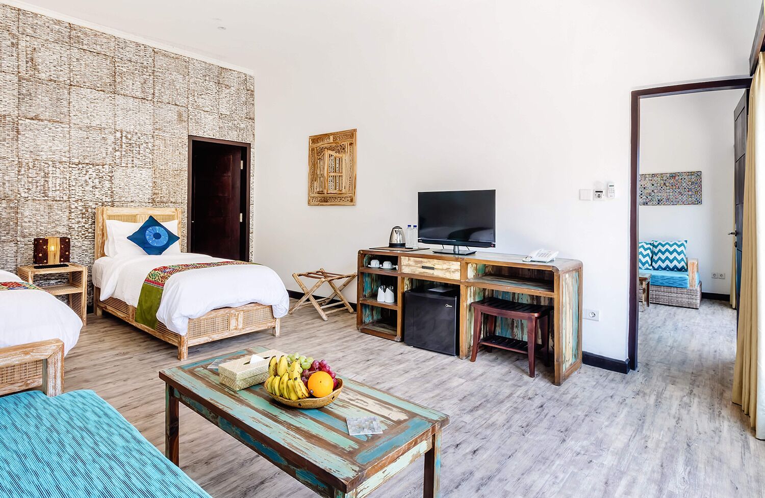 A room with a bed, a desk, a television, and a small refrigerator.