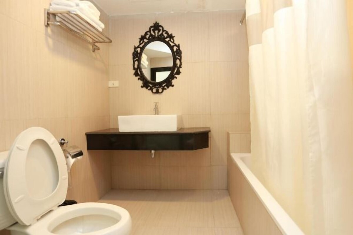 A small bathroom with a toilet, sink, and mirror.
