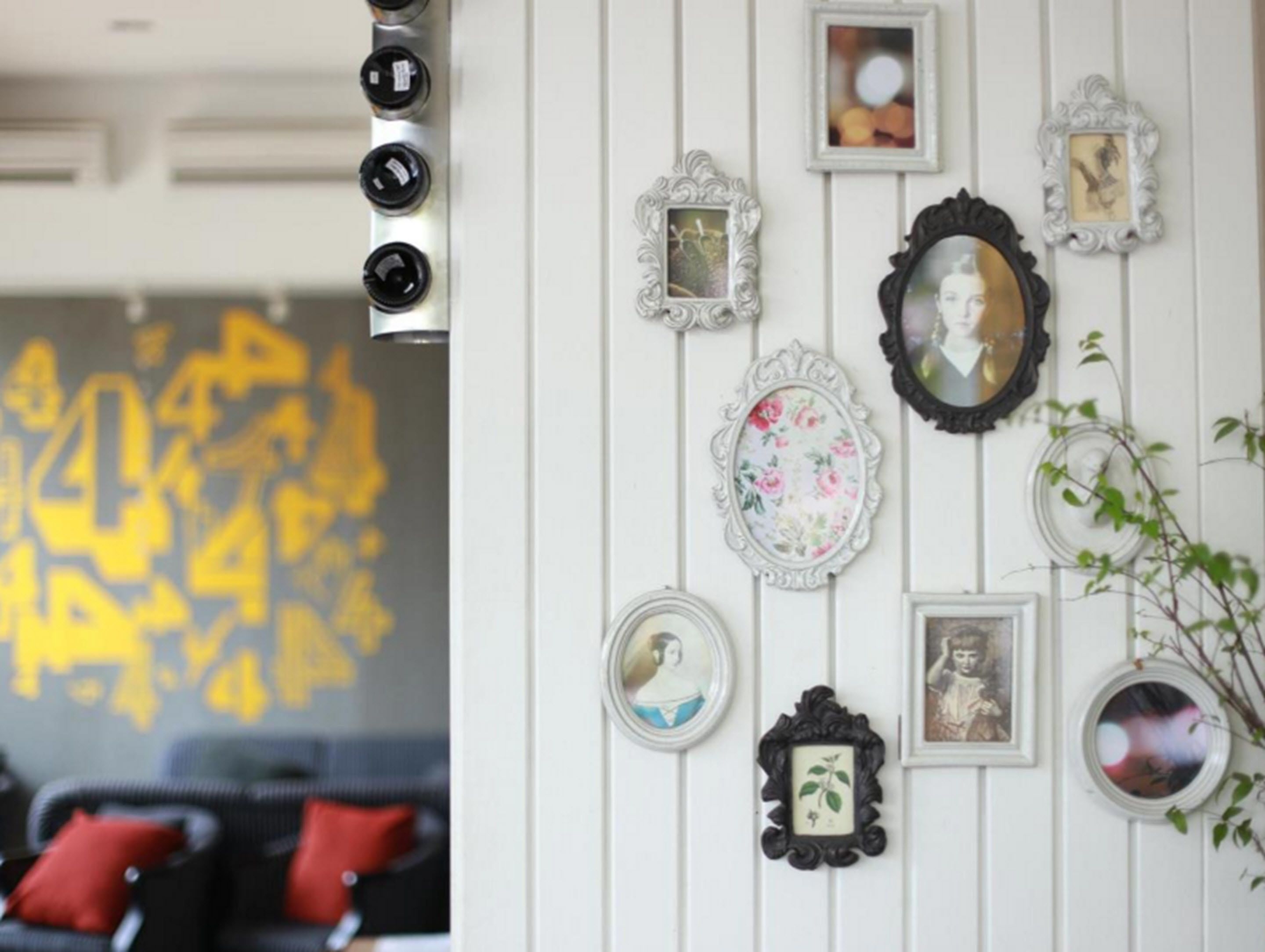 A wall with various framed pictures and a decorative mirror.