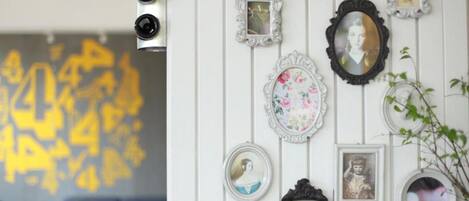 A wall with various framed pictures and a decorative mirror.