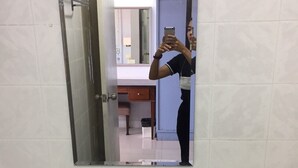 A bathroom with a sink, mirror, and two bottles of shampoo.