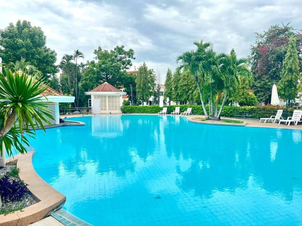 A swimming pool with lounge chairs and a gazebo.