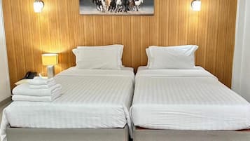 Parivuode valkoisilla lakanoiden, yöpöydällä ja seinällä oleva hevosaiheinen taulu.