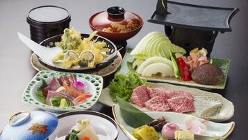 A variety of Japanese dishes including sushi, sashimi, and tempura, served on traditional ceramic plates and bowls.