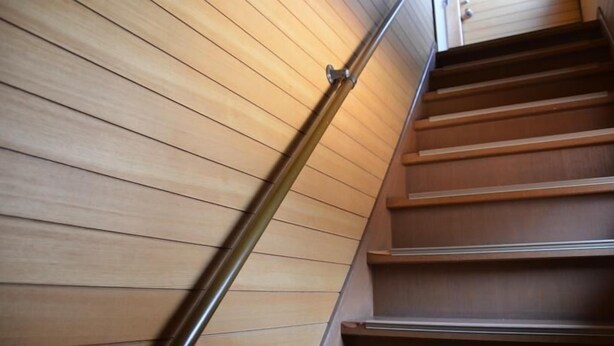 Una escalera de madera con barandilla de metal.