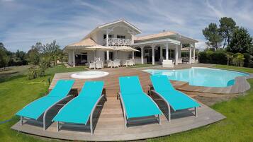 Relax by the large pool surrounded by lush lawns and trees.