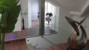A modern interior with a glass partition, a metal sculpture, and a potted plant. - Villa Bora Bora (Gujan-Mestras)