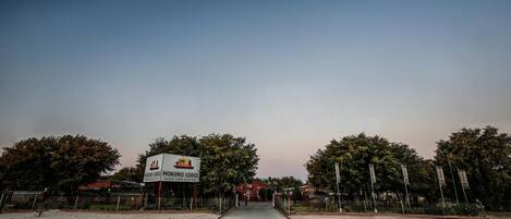 Una carretera que lleva a un edificio con un cartel que dice "MOKRO LODGE".
