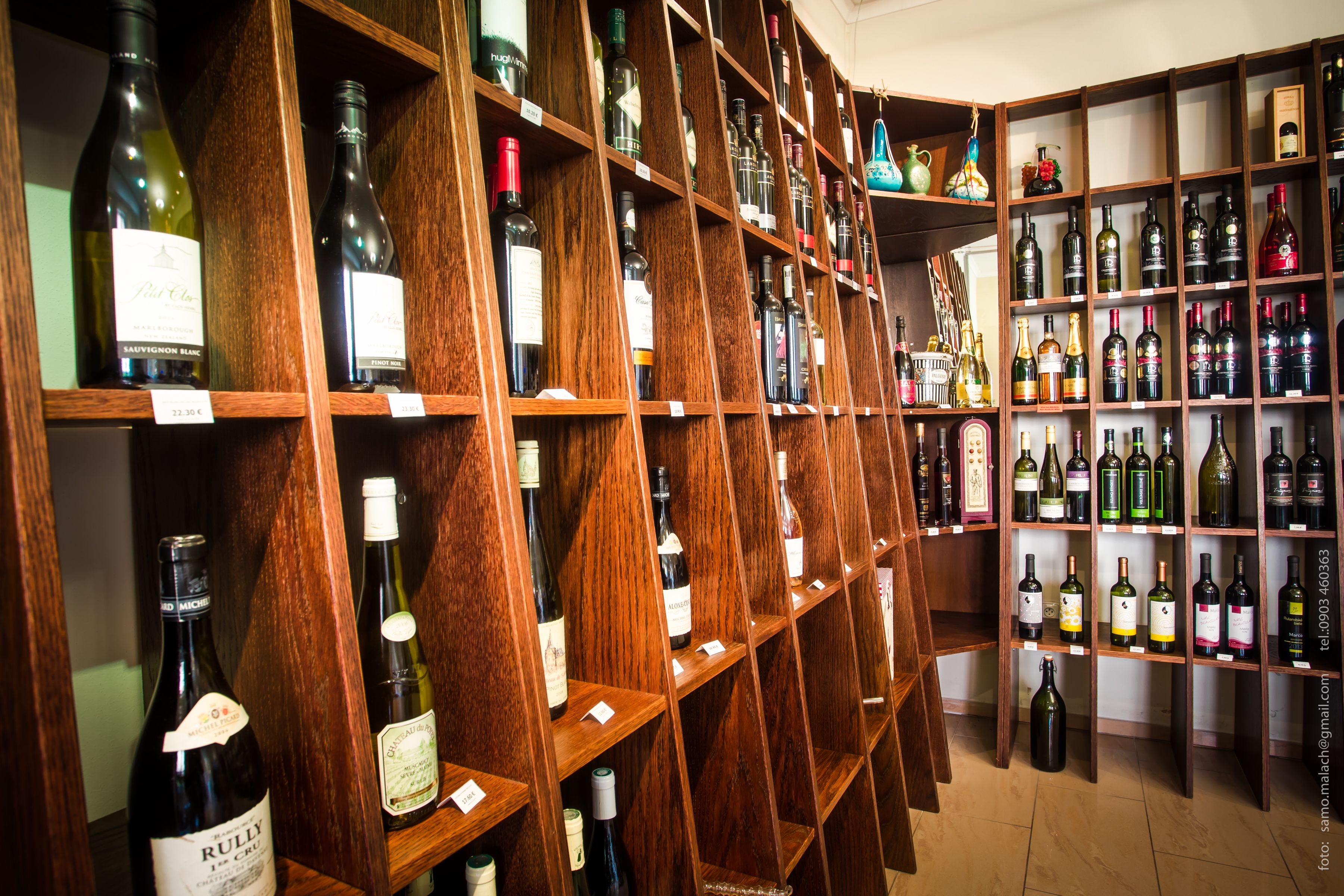 Una bodega con estantes de madera llenos de diversas botellas de vino.