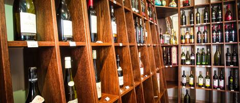 Una bodega con estantes de madera llenos de diversas botellas de vino.