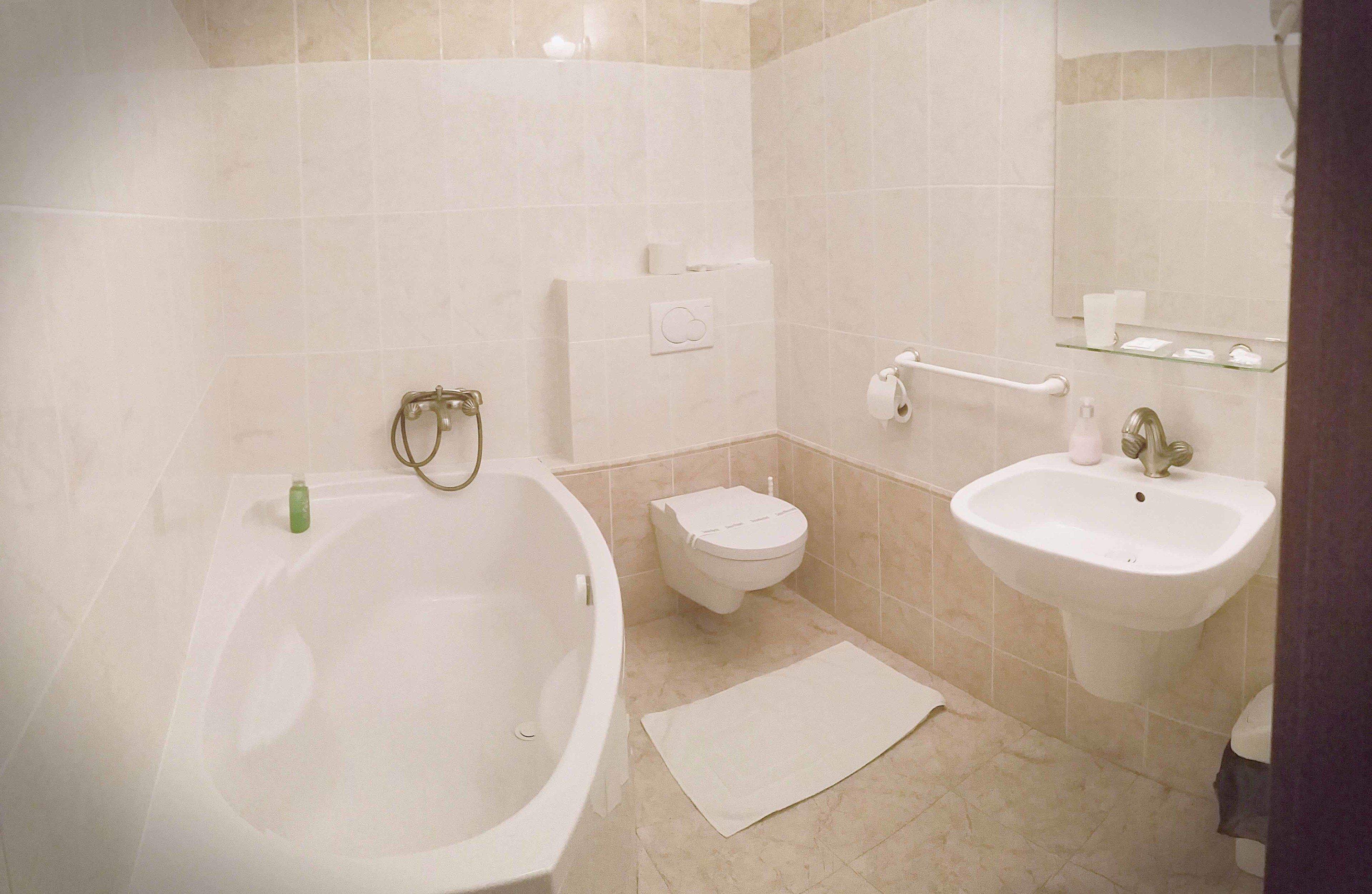A bathroom with a bathtub, toilet, and sink.