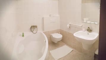 A bathroom with a bathtub, toilet, and sink.