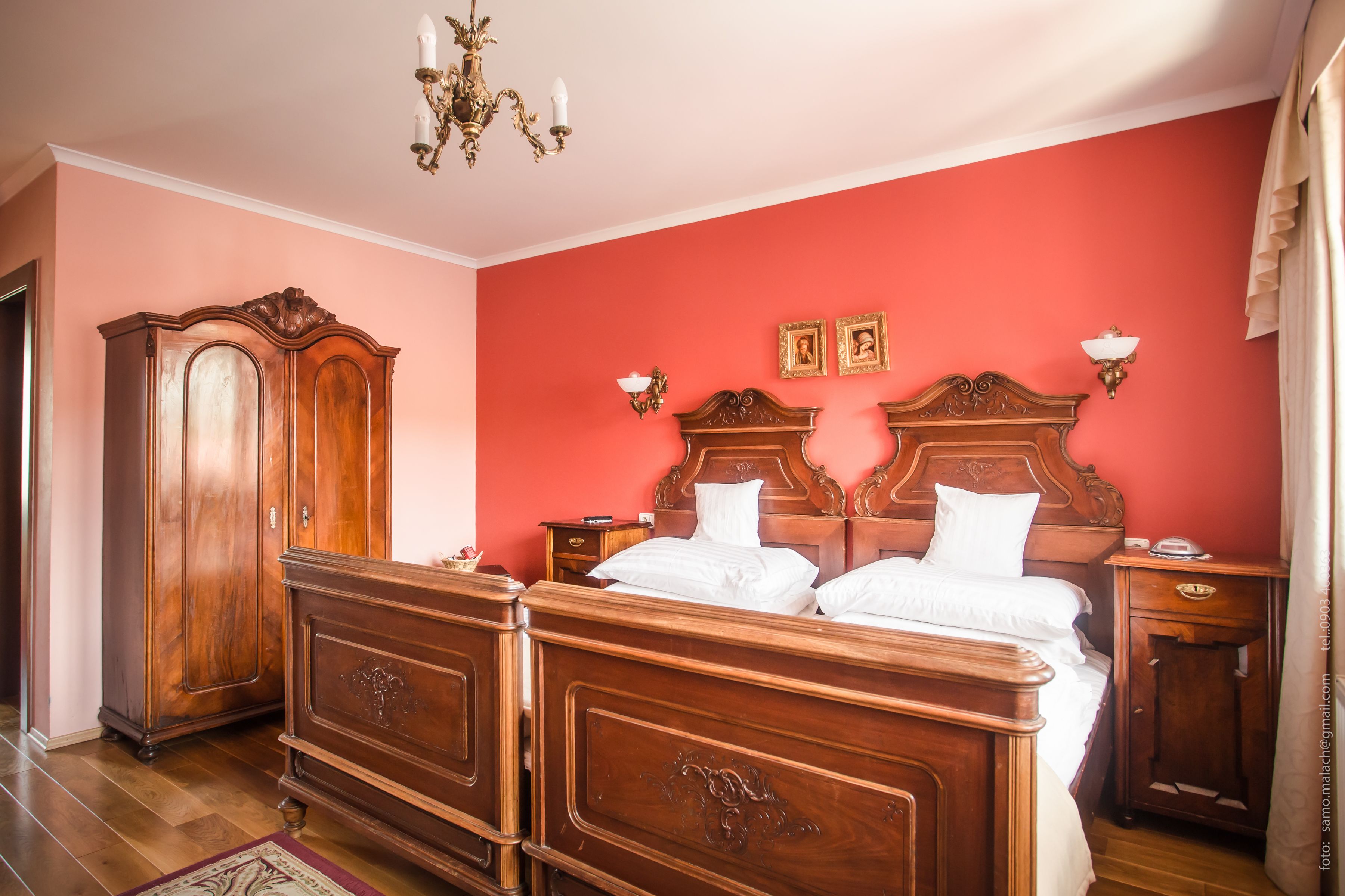 Une chambre à coucher avec un grand lit en bois, une armoire et un lustre.