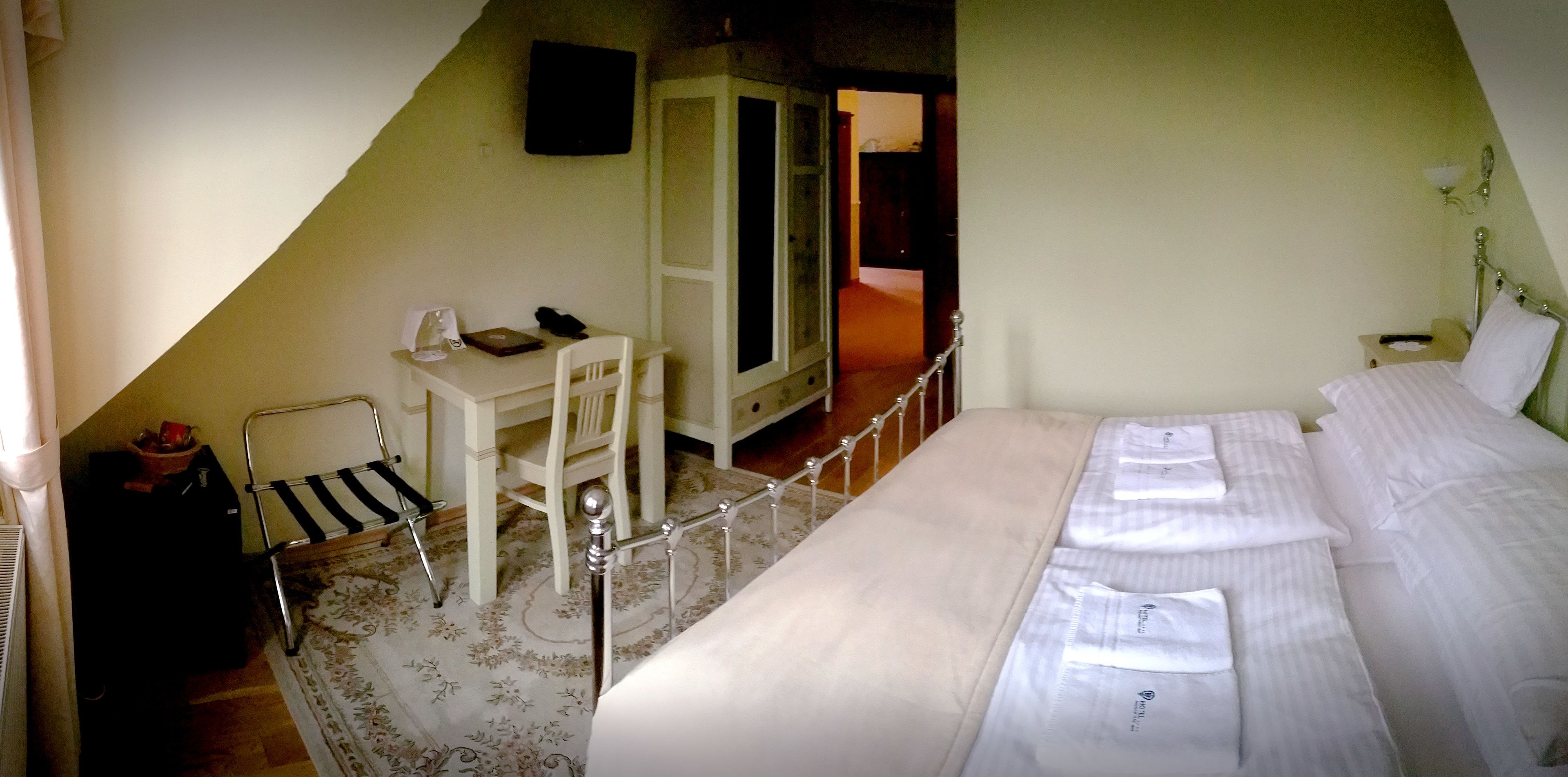 Un dormitorio con cama, escritorio y silla.