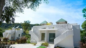 Een moderne villa met een uniek architectuurontwerp, met meerdere verdiepingen en een opvallende trap.
