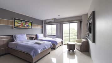 A modern hotel room with two beds, a small round table, a TV mounted on the wall, and a large window with curtains.