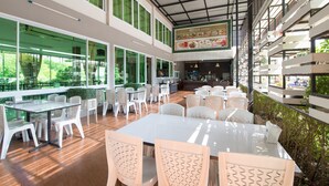 Un amplio comedor interior con techos altos, ventanas grandes y una zona de cocina central.