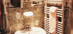A bathroom with a sink, towel rack, and decorative tiles. - Auberge d'Alle (Vresse-sur-Semois)