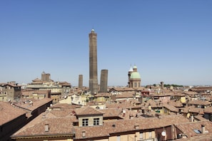 A historic cityscape with a prominent tower and domed buildings. - Casa Isolani Santo Stefano (Bologna)