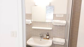 A bathroom with a white sink, a mirror, and a towel rack.
