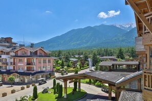 A hotel with a covered outdoor area, a mountain backdrop, and a well-maintained garden. - Pirin Golf Hotel & SPA (Razlog)