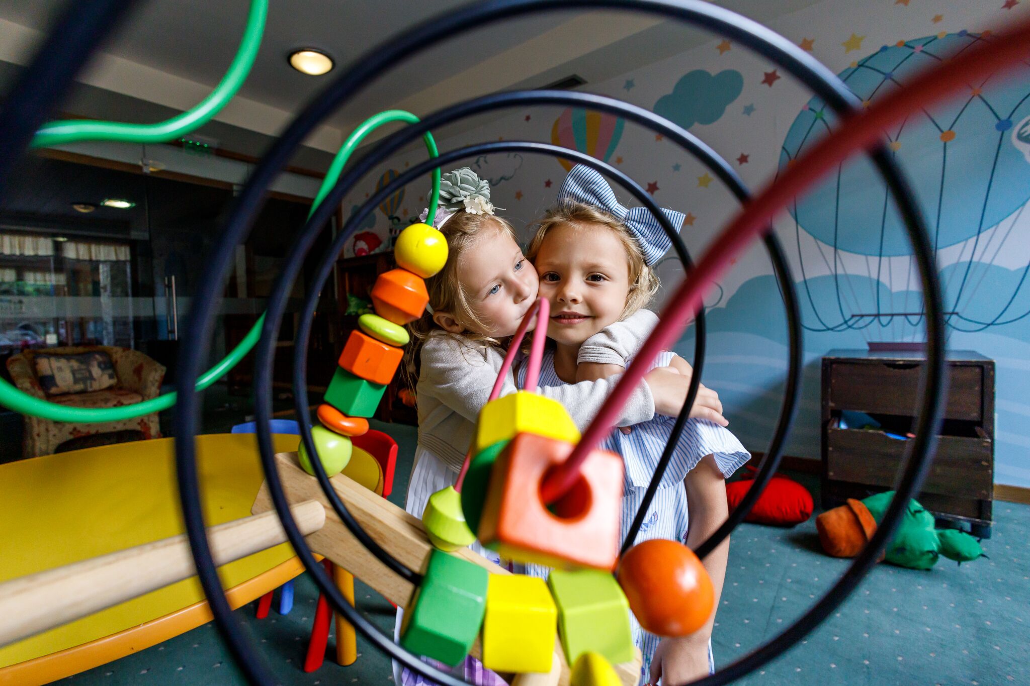 A child playing with a colorful bead maze toy.