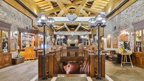 A spacious lobby with a high wooden ceiling, stone walls, and a central staircase. - Pirin Golf Hotel & SPA (Razlog)
