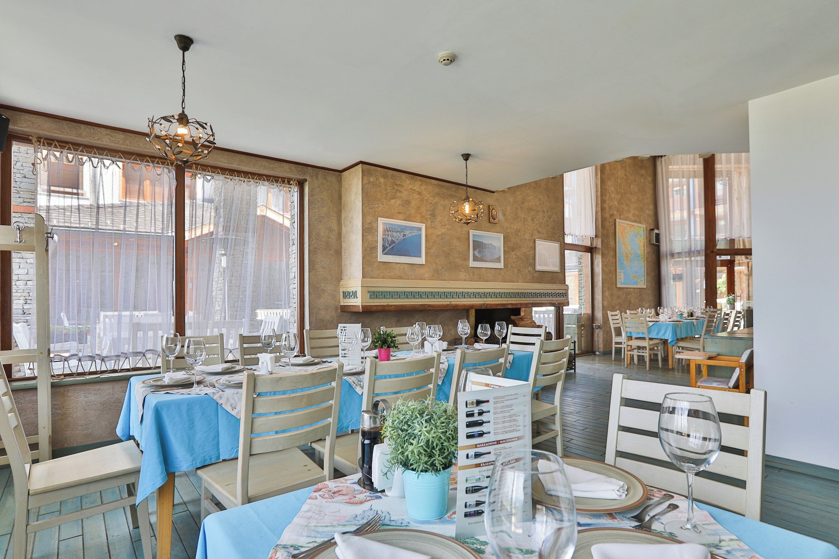 Un restaurante con varias mesas, sillas y un atril para el menú.
