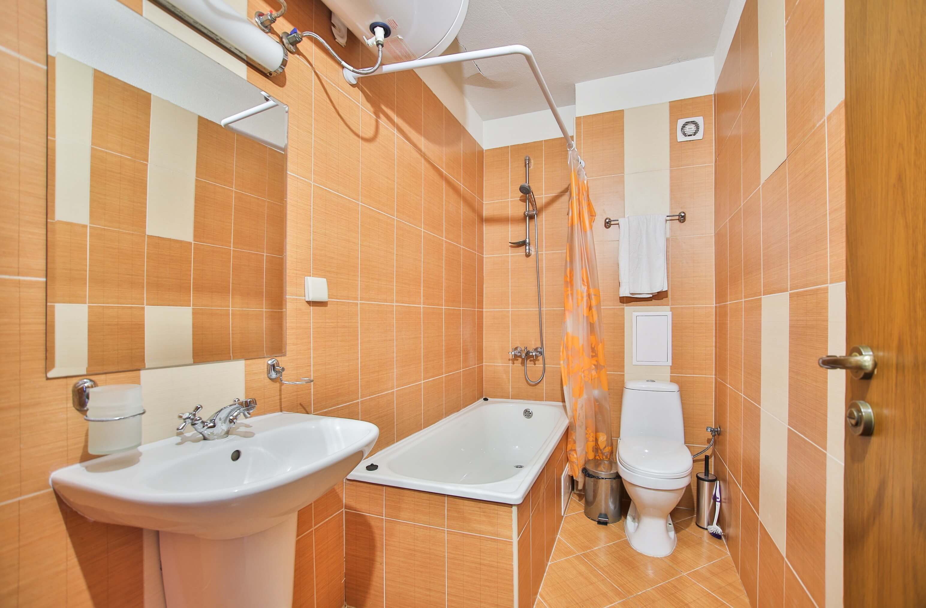 A bathroom with a sink, bathtub, toilet, and shower curtain.