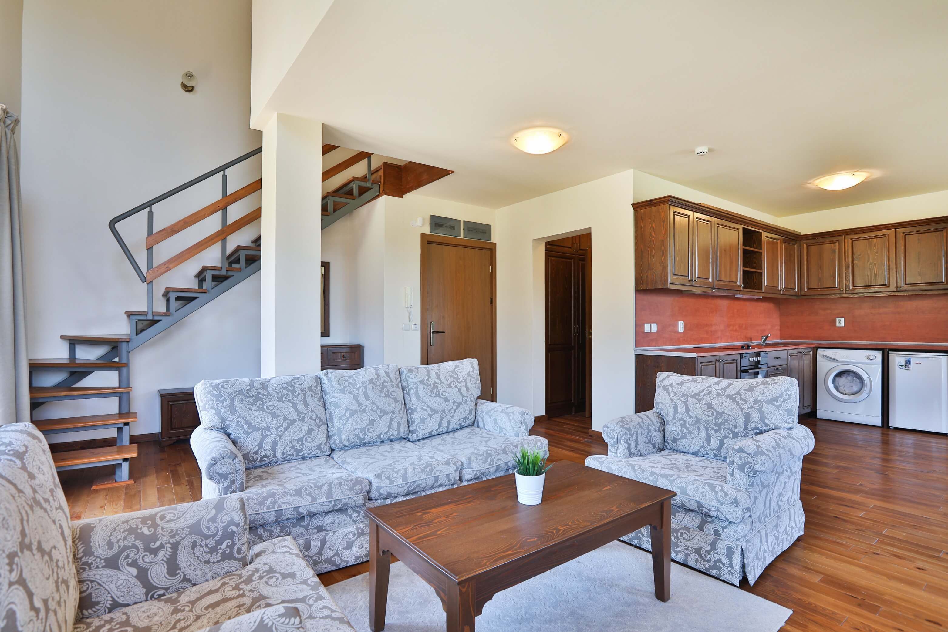 Un vaste espace de vie comprenant un canapé, une table basse et un escalier.