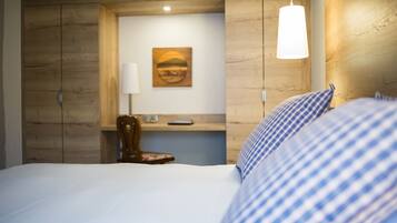 Ein Hotelzimmer mit einem Bett, einem Sessel, einem Schreibtisch und einem Bild an der Wand.