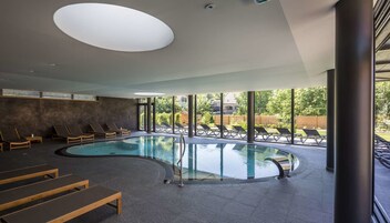 Una piscina techada, sillones reclinables de piscina