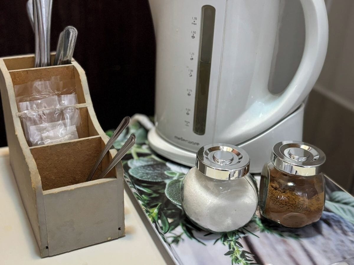 A kitchen counter with a coffee maker, salt and pepper shakers, and a utensil holder.