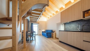 Cocina moderna con armarios de madera, encimera negra y estufa integrada.
