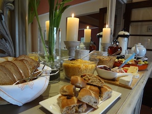 A breakfast buffet with bread, pastries, and various breakfast items.