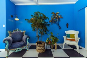 A room with a checkered floor, a blue wall, and two chairs. - Modern Hotel Aruba (Noord)