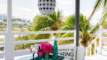 A table with a bottle, glasses, and flowers, with a sign saying "Perfect is boring."