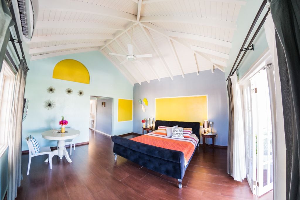 Ein Schlafzimmer mit einem Bett, einem runden Tisch mit Stühlen und einem Deckenventilator.